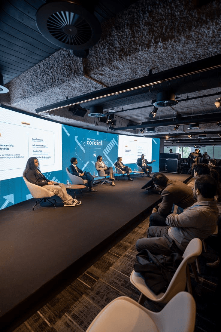Panel discussion at Instituto Cordial with attendees seated in front of the stage.